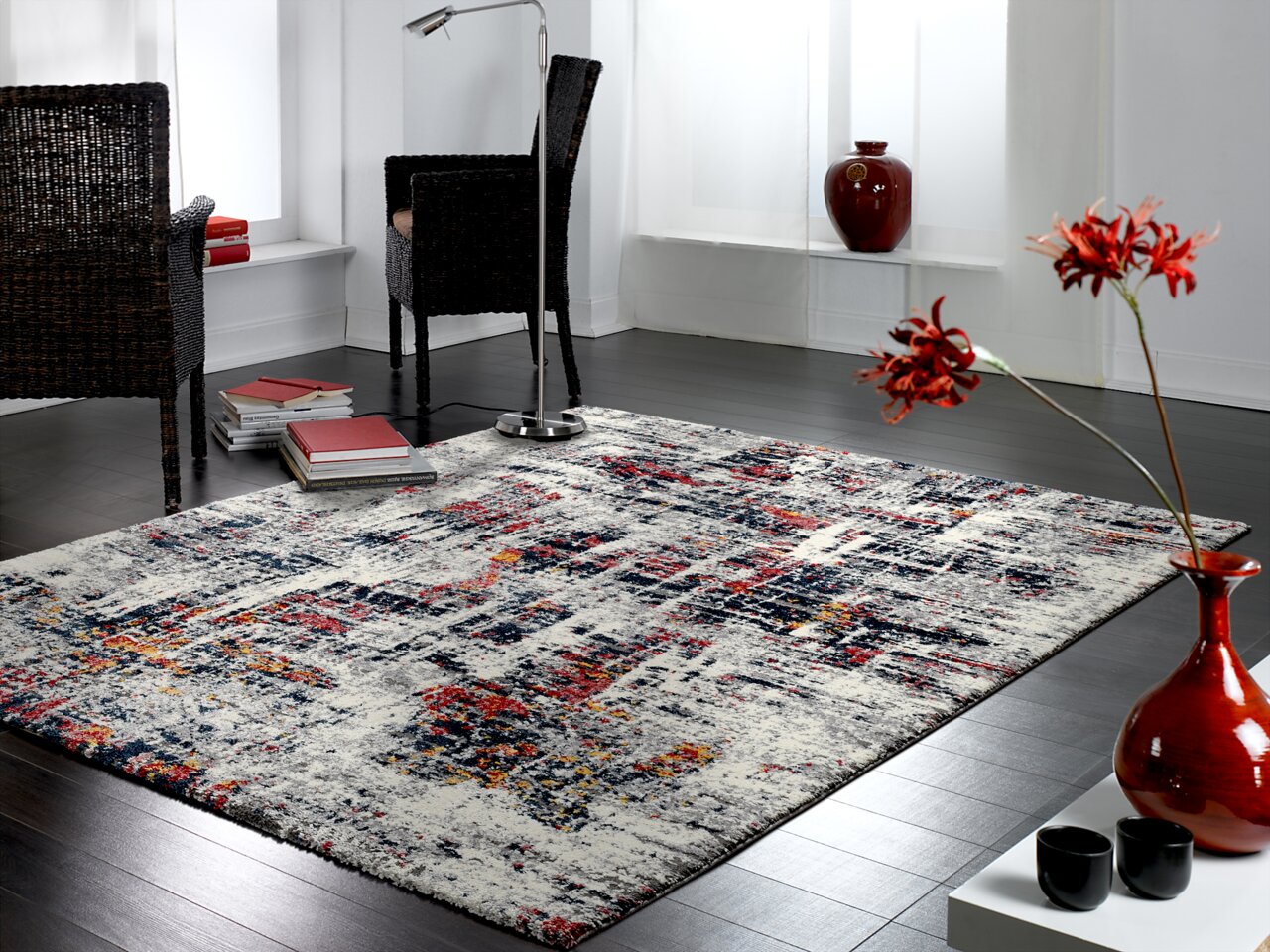 Moderner Designer Teppich in einem stilvollen Wohnzimmer mit dunklem Holzboden, roten Akzenten und eleganten Möbeln, aus einer seitlichen Perspektive fotografiert.