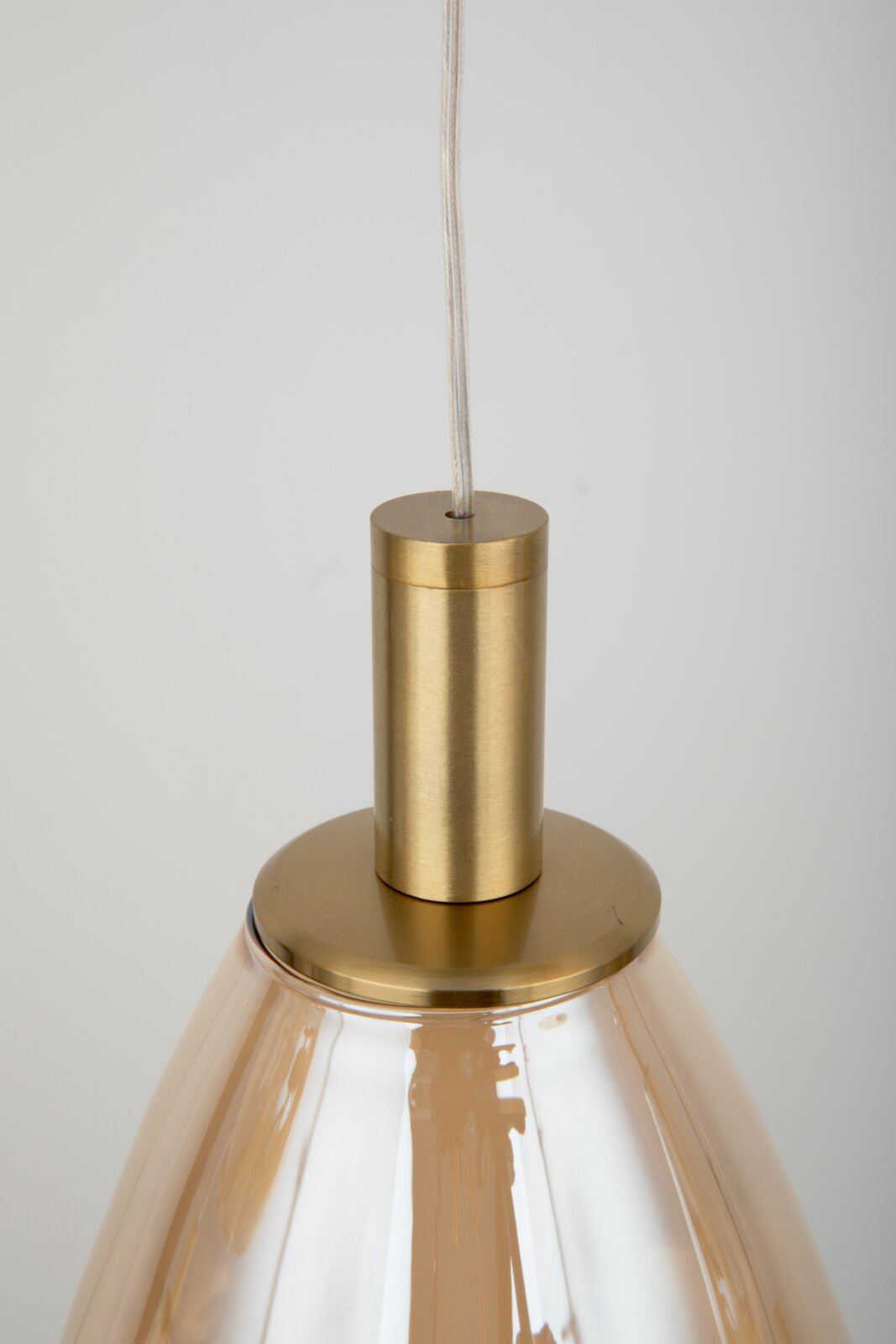 Nahaufnahme einer LED-Hängeleuchte mit goldener Fassung und transparentem Schirm, von unten fotografiert.