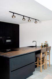 Moderne schwarze Strahler DORIAN TRACK von Lucide an der Decke einer stilvollen Küche, seitliche Perspektive.
