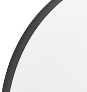 Nahaufnahme eines runden Spiegels mit schwarzem Rahmen, perspektivisch von der Seite aufgenommen.