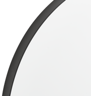 Nahaufnahme eines runden Spiegels mit schwarzem Rahmen, perspektivisch von der Seite aufgenommen.