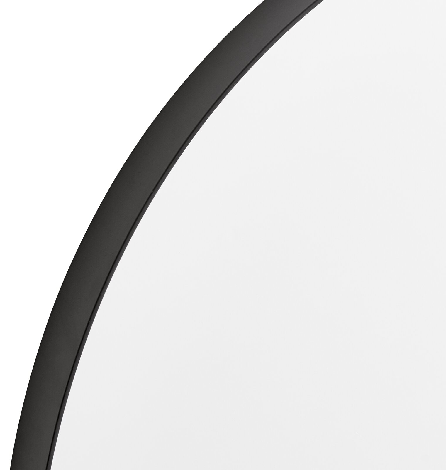 Nahaufnahme eines runden Spiegels mit schwarzem Rahmen, perspektivisch von der Seite aufgenommen.