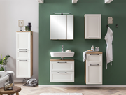 Moderner Badezimmer-Unterschrank in Weiß mit Holzdetails, frontal vor einer grünen Wand montiert.