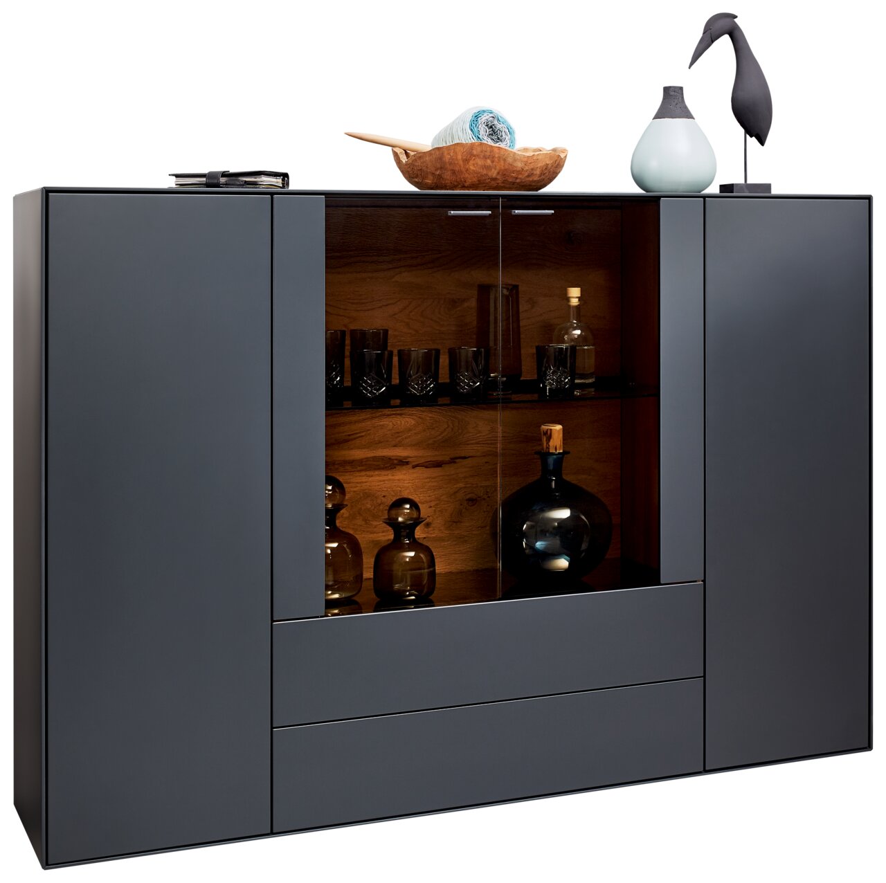 Modernes Highboard mit dunkler Holzoptik und Glasvitrine, frontal betrachtet. Dekoriert mit Vasen und einer Holzschale.