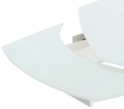 Nahaufnahme eines modernen Esstisches mit abgerundeten Kanten und weißer Glasoberfläche, von oben betrachtet.