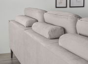 Rückansicht einer grauen Rundecke mit verstellbaren Kopfstützen, perspektivisch von hinten links aufgenommen.