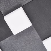 Detailansicht aus der Untersicht einer modernen Deckenleuchte mit schwarz gebürsteter Oberfläche und quadratischen weißen Leuchtflächen