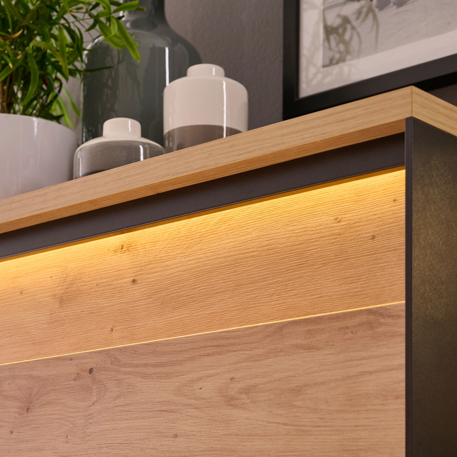 Detailansicht einer Vitrine mit Holzoberfläche und integrierter Beleuchtung, von oben fotografiert.