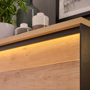 Detailansicht einer Vitrine mit Holzoberfläche und integrierter Beleuchtung, von oben fotografiert.