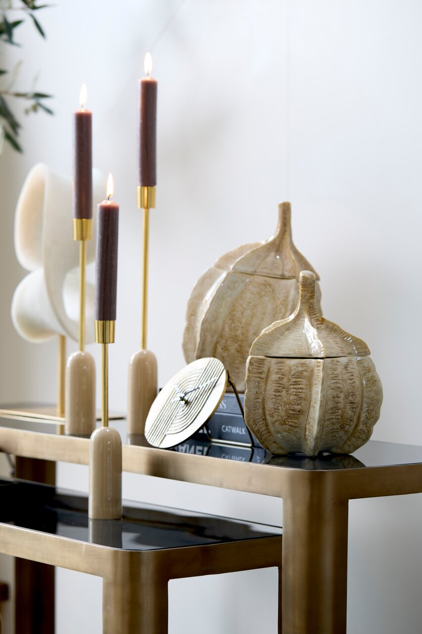 Light&Living Decoratiebox SABARA Decoratieve doos in de vorm van een pompoen op een tafel, omringd door elegante kandelaars en boeken, zijaanzicht.