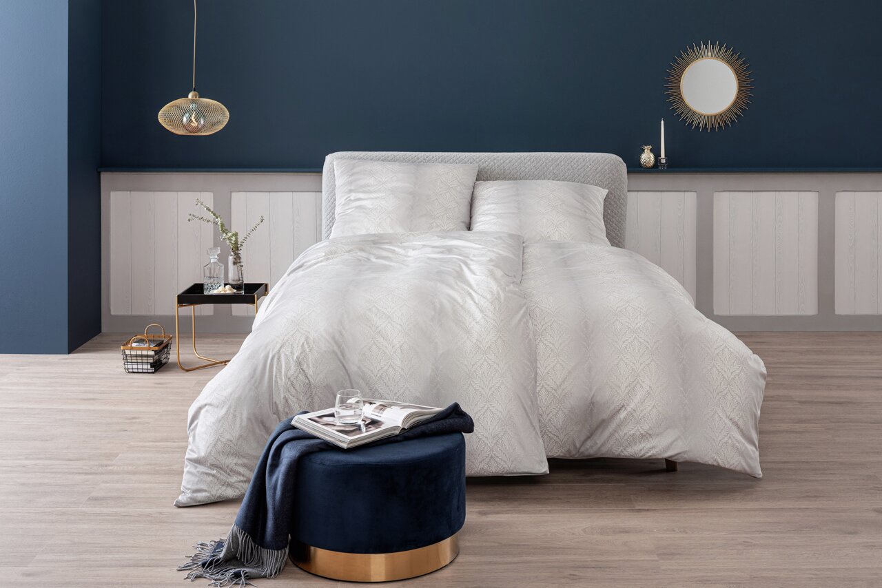 Elegante Bettwäsche in einem stilvollen Schlafzimmer, frontal aufgenommen.