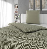 Bettwäsche-Set mit geometrischem Muster in Grün und Weiß auf einem Bett, seitliche Perspektive