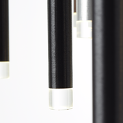 Nahaufnahme von hängenden, zylindrischen LED-Leuchten mit schwarzem Gehäuse und transparentem Ende, seitliche Perspektive