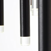 Nahaufnahme von hängenden, zylindrischen LED-Leuchten mit schwarzem Gehäuse und transparentem Ende, seitliche Perspektive