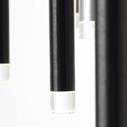 Nahaufnahme von hängenden, zylindrischen LED-Leuchten mit schwarzem Gehäuse und transparentem Ende, seitliche Perspektive