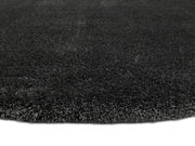 Nahaufnahme eines dunkelgrauen Hochflor-Teppichs aus seitlicher Perspektive.