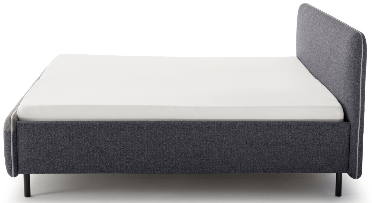 Seitliche Ansicht eines grauen Polsterbetts mit weißer Matratze und hohem Kopfteil.