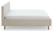 Seitliche Ansicht eines Polsterbettgestells mit hellem Stoffbezug und Holzfüßen.