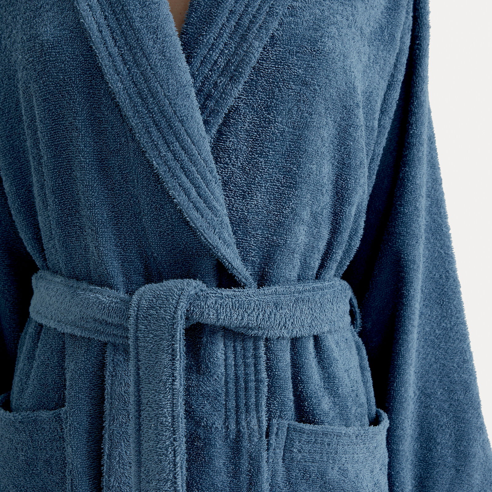 Nahaufnahme eines blauen Bademantels mit Schalkragen und Gürtel, Vorderansicht.