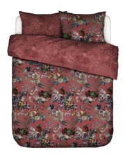 Bettwäsche-Set in Rostrot mit üppigem mehrfarbigem Blumenmuster und dezentem Ton-in-Ton-Blumendessin auf der Wendeseite, aus erhöhter Frontalperspektive auf einem Doppelbett präsentiert