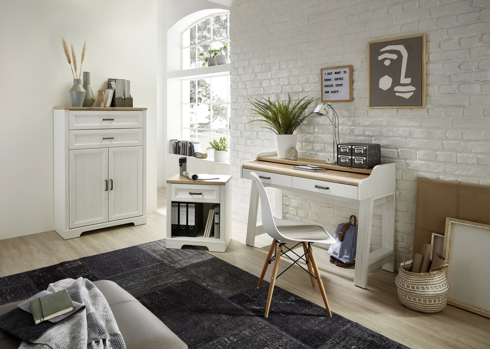 Heller Raum mit einem weißen Regalschrank der Serie JUDITH, einem Schreibtisch und einem Stuhl, aus der Perspektive von vorne betrachtet.