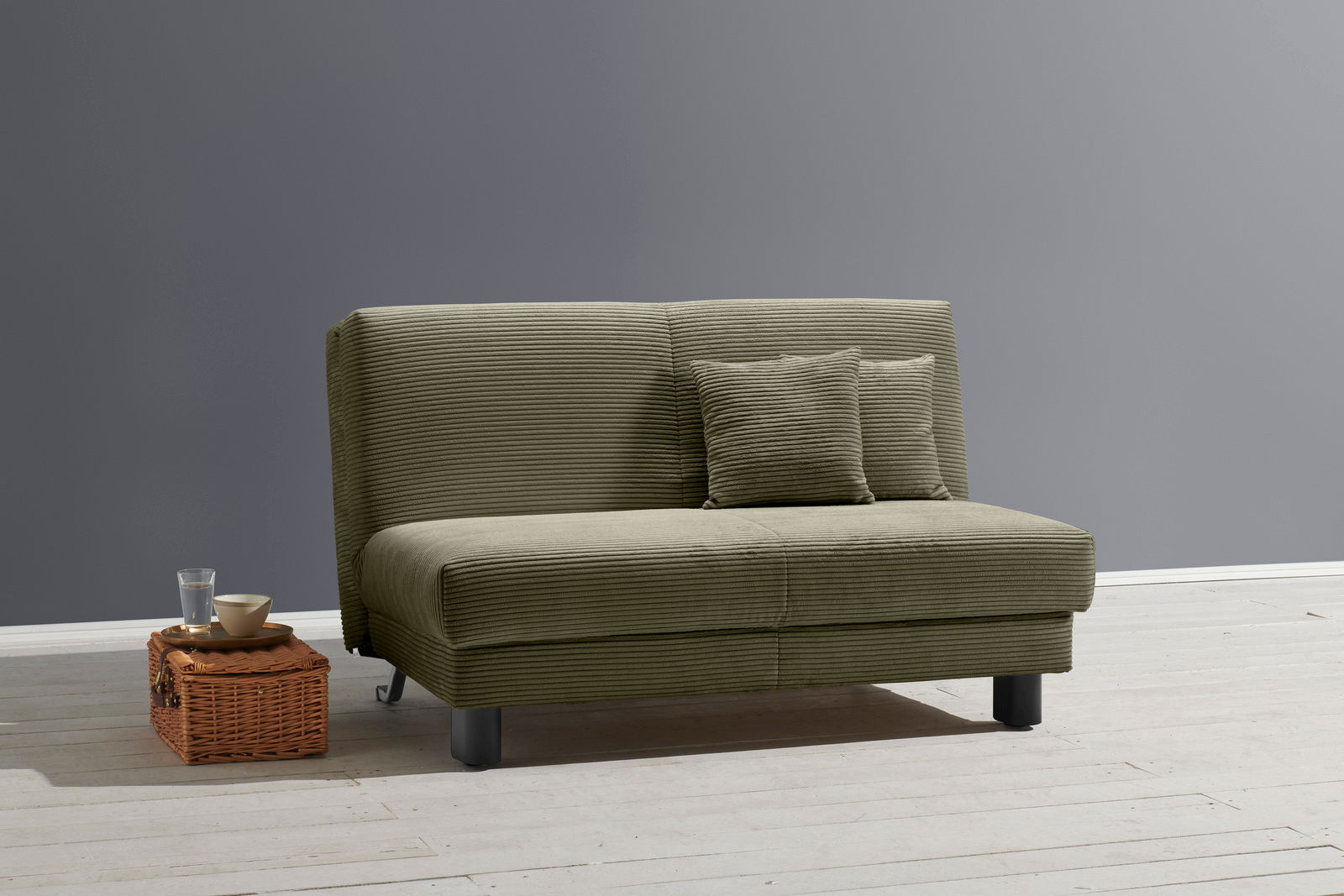 Grünes Funktionssofa mit zwei Kissen, seitliche Perspektive