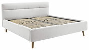 Seitliche Perspektive auf ein modernes Polsterbett mit hellem Stoffbezug und Holzfüßen, Modell LOTTE.