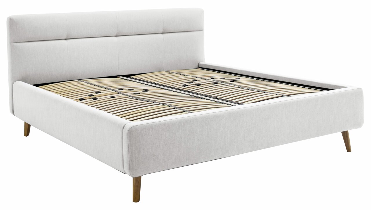 Seitliche Perspektive auf ein modernes Polsterbett mit hellem Stoffbezug und Holzfüßen, Modell LOTTE.