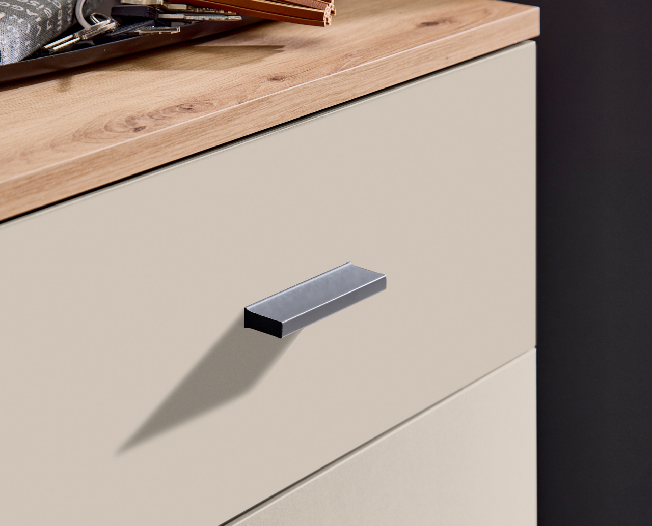 Nahaufnahme einer Kompaktgarderobe mit Holzoberfläche und modernem Griff, seitliche Perspektive