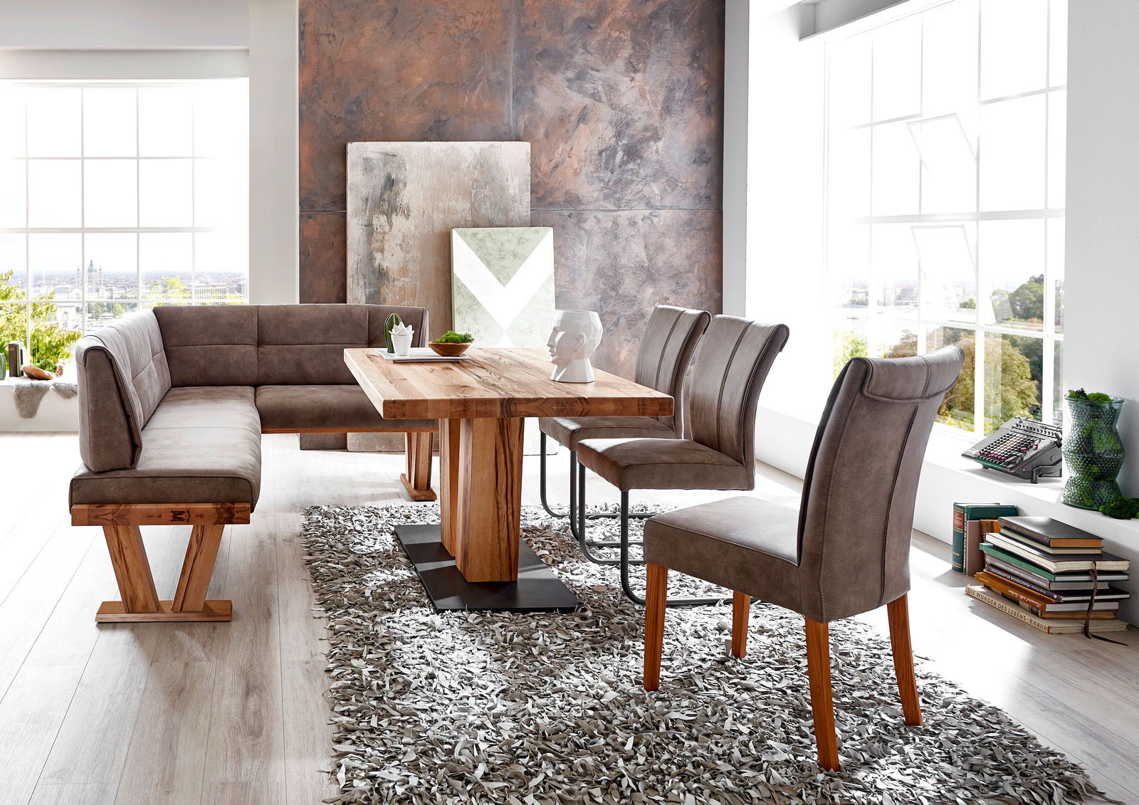 Moderne Esszimmer-Einrichtung mit Eckbank, Esstisch und Stühlen in einem hellen Raum, seitliche Perspektive