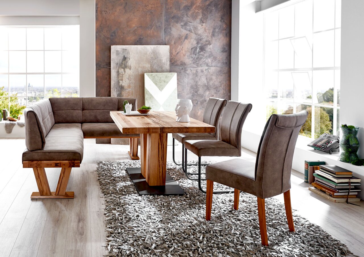 Moderne Esszimmer-Einrichtung mit Eckbank, Esstisch und Stühlen in einem hellen Raum, seitliche Perspektive