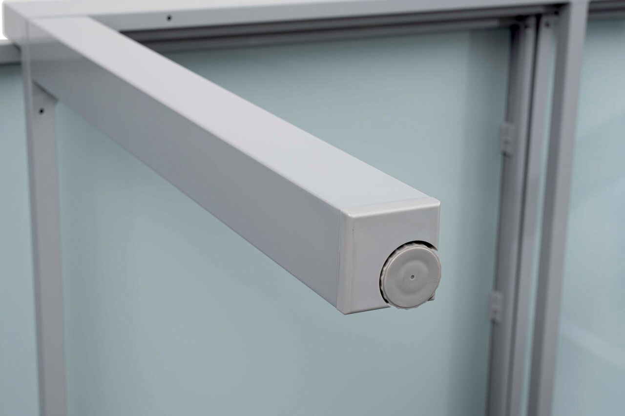 Nahaufnahme eines silbernen Metallrahmens eines Gartentisches aus seitlicher Perspektive.