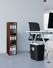 Schwarzer Aktenvernichter mit silbernem Deckel unter einem Büroschreibtisch, seitliche Perspektive im modernen Büro