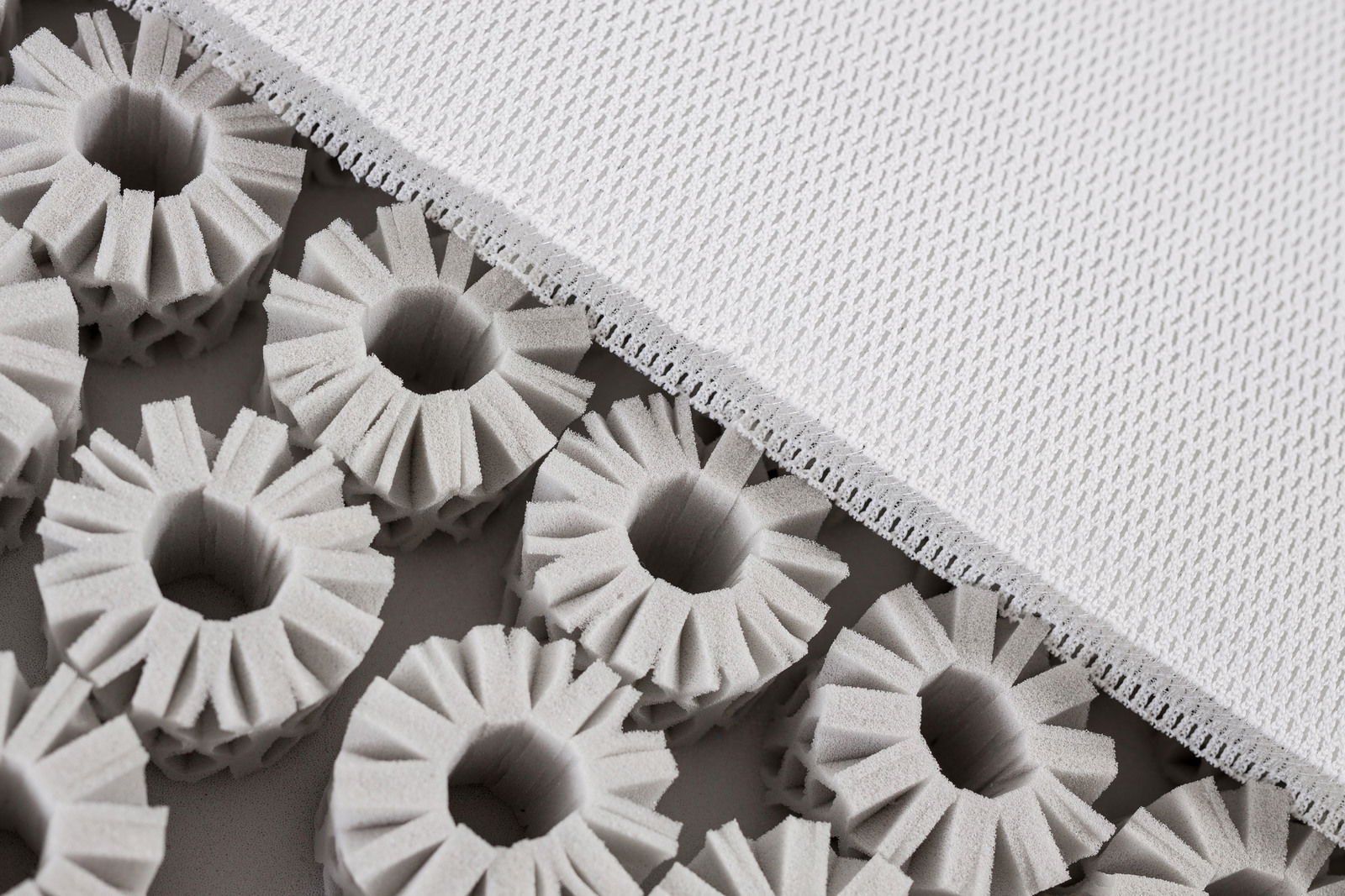 Nahaufnahme einer Matratze mit offenem Schaumstoffkern und weißem Bezug, von oben betrachtet.