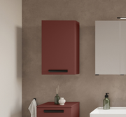 Moderner Hängeschrank in Rot mit schwarzem Griff, frontal betrachtet, neben einem weißen Schrank und über einem Waschbecken platziert.