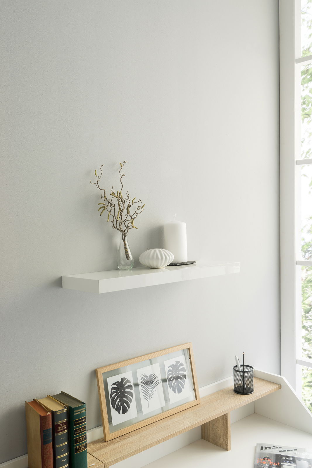 Wandboard in moderner, minimalistischer Einrichtung mit Dekorationen aus Kerzen und Vasen, seitliche Perspektive