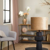 Moderner Lampenschirm Zylinder in Beige auf schwarzem Sockel, seitliche Perspektive in stilvollem Wohnzimmer.