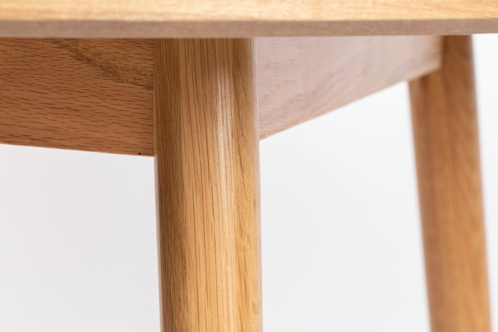 Nahaufnahme eines Esstischbeins aus Holz mit natürlicher Maserung, seitliche Perspektive