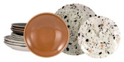 Stapel aus Keramikgeschirr mit gesprenkelten Teller/Platten und einer braunen Schale im Vordergrund, Studioaufnahme in leichter Schrägansicht von vorn auf weißem Hintergrund.