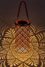 Solarbetriebene Laterne mit dekorativem Muster, das ein warmes Licht und faszinierende Schatten wirft, seitliche Perspektive