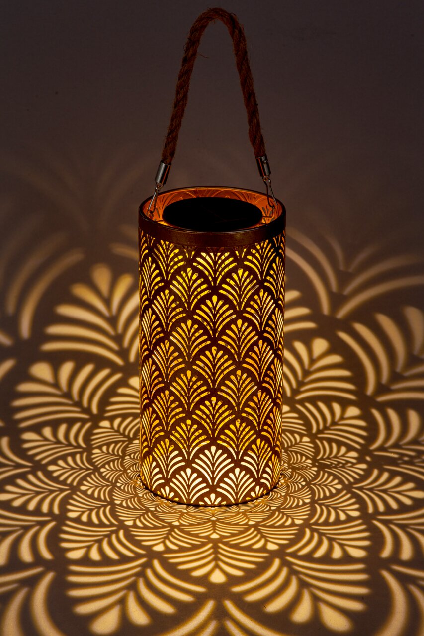 Solarbetriebene Laterne mit dekorativem Muster, das ein warmes Licht und faszinierende Schatten wirft, seitliche Perspektive