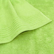 Nahaufnahme eines limettengrünen Handtuchs mit feiner Struktur und dekorativen Streifen am Rand.