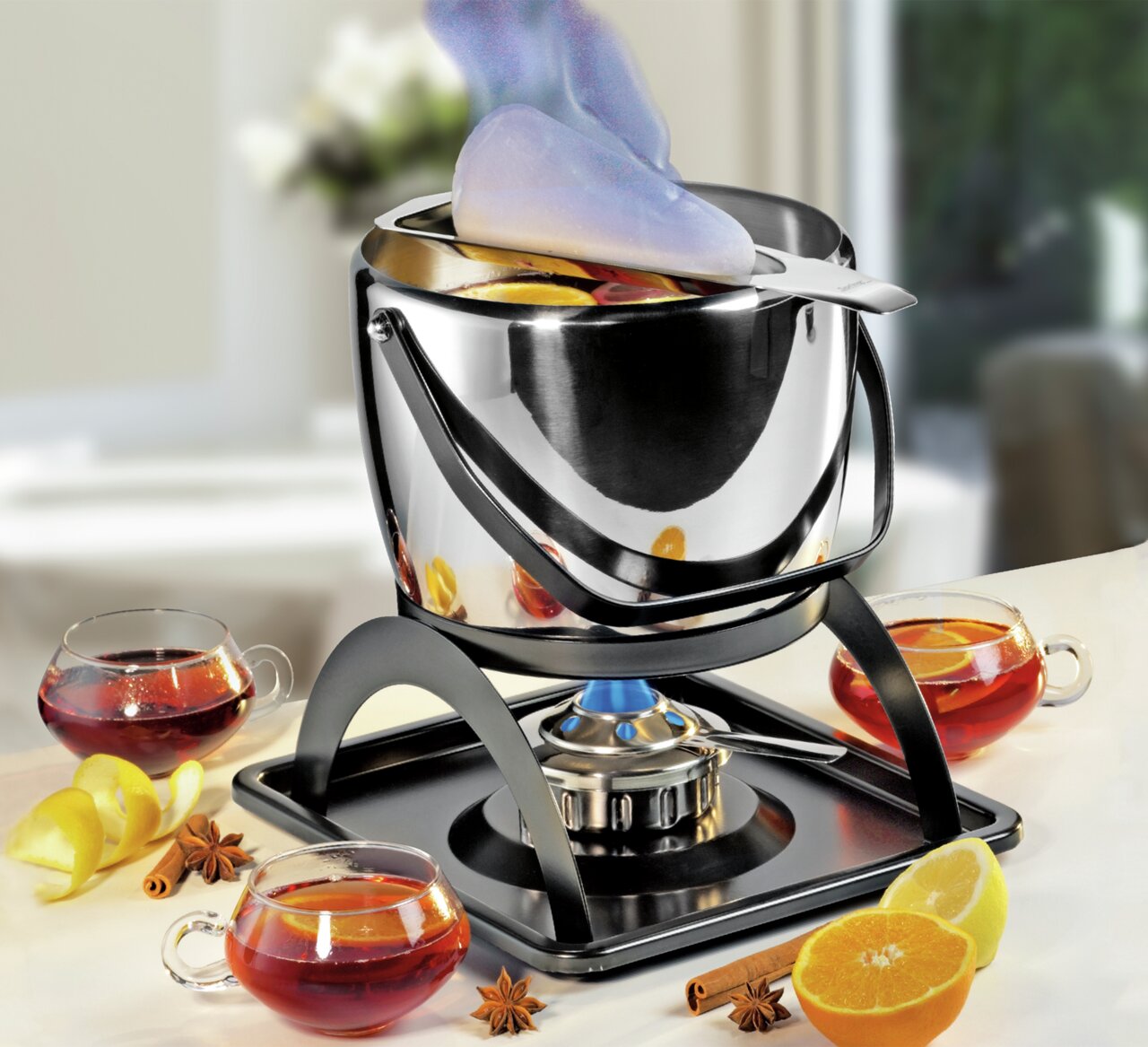 Feuerzangenbowle-Set mit brennendem Zuckerhut, umgeben von Gläsern mit heißem Getränk, Zitrusfrüchten und Gewürzen, aus seitlicher Perspektive.