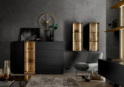 Modern hoogkast in zwart met gouden accenten, gefotografeerd vanaf de voorkant. Versierd met vazen en kunstvoorwerpen, omringd door stijlvolle wandplanken en een fauteuil.