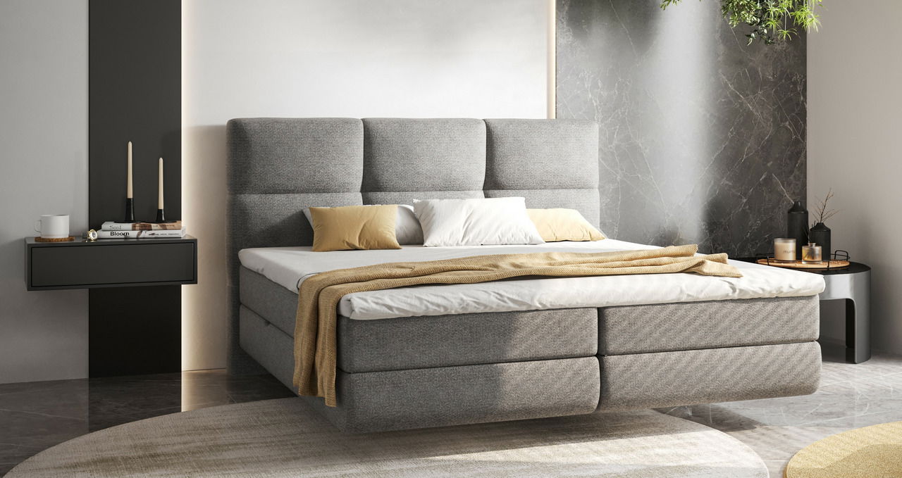 Modernes Boxspringbett in grauem Stoff mit hohem Kopfteil, dekoriert mit Kissen und Decke, seitliche Perspektive