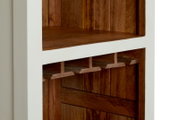 Close-up van een houten barkast met wit frame en ingebouwde glazenhouders, gezien vanaf de zijkant.