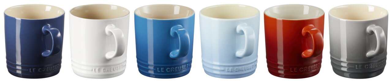 Sechs Le Creuset Keramikbecher in verschiedenen Farben (dunkelblau, weiß, blau, hellblau, rot, grau) in Frontansicht mit sichtbarem Henkel, freigestellt auf weißem Hintergrund