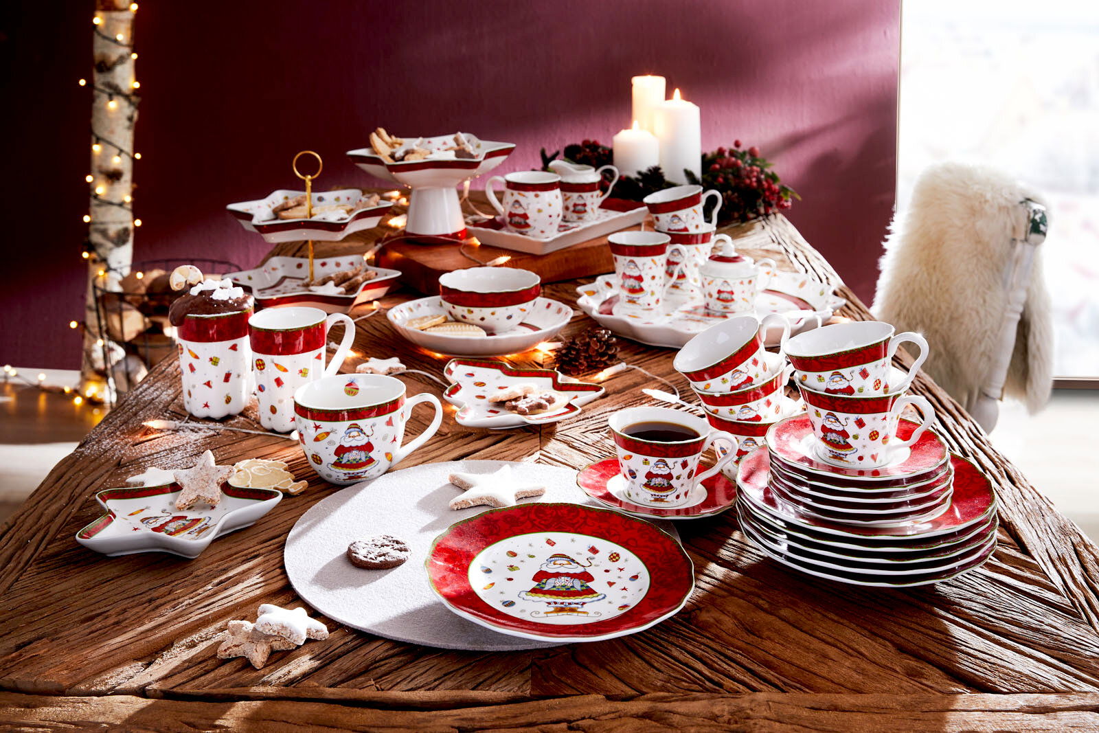 Weihnachtliches Kaffeeservice auf einem Tisch, bestehend aus Tassen, Tellern und Schalen mit festlichem Design, aus der Vogelperspektive fotografiert.