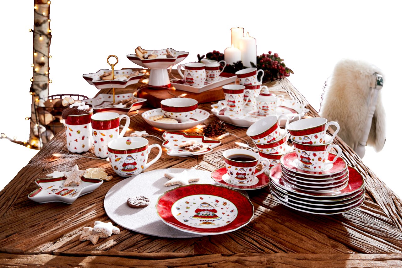 Weihnachtliches Kaffeeservice auf einem Tisch, bestehend aus Tassen, Tellern und Schalen mit festlichem Design, aus der Vogelperspektive fotografiert.
