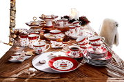 Weihnachtliches Kaffeeservice auf einem Tisch, bestehend aus Tassen, Tellern und Schalen mit festlichem Design, aus der Vogelperspektive fotografiert.
